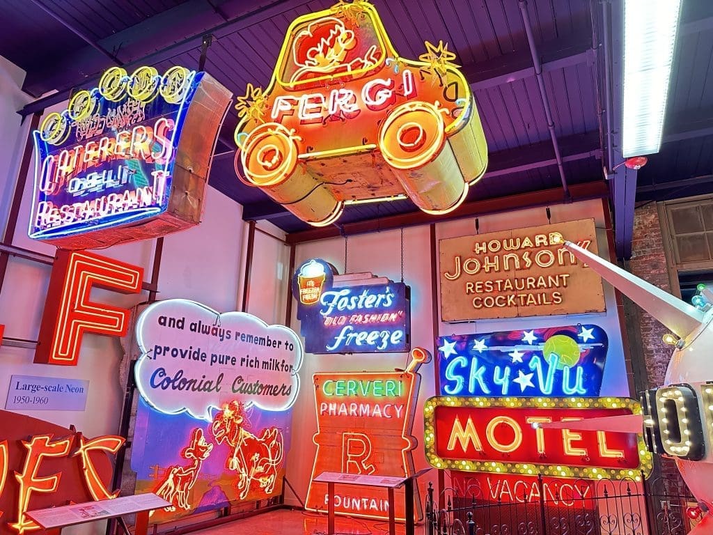 A vibrant wall of colorful neon signs in various styles and languages.