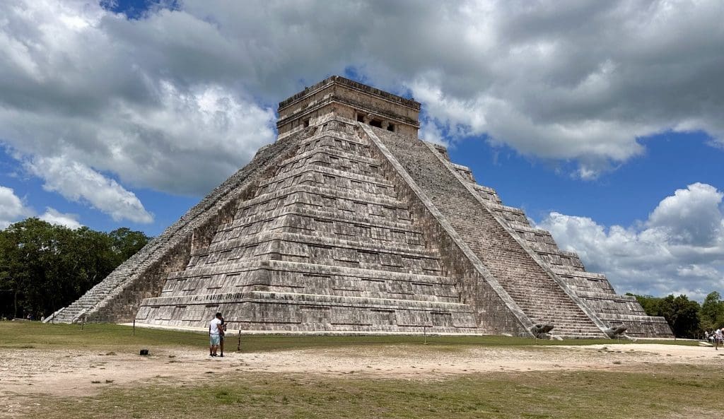 The ancient pyramid of Chichen Itza under a cloudy sky.