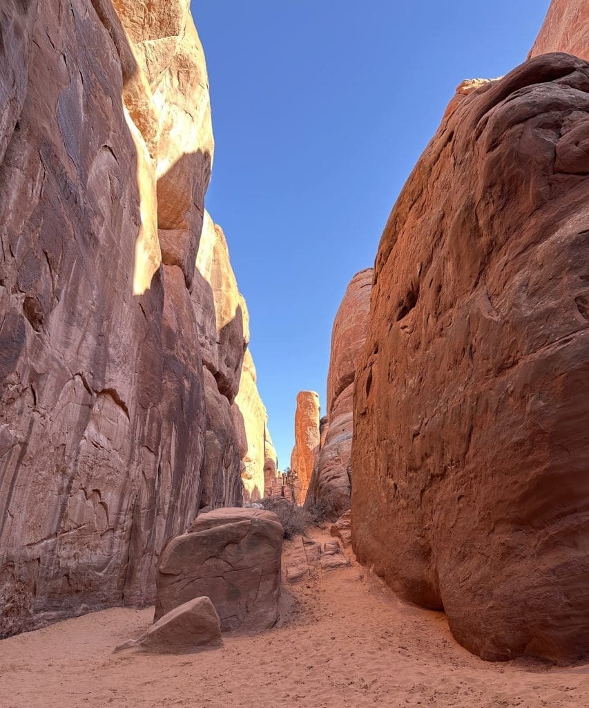 Walk through slot canyon and rock structures on way to Sand Dune Arch