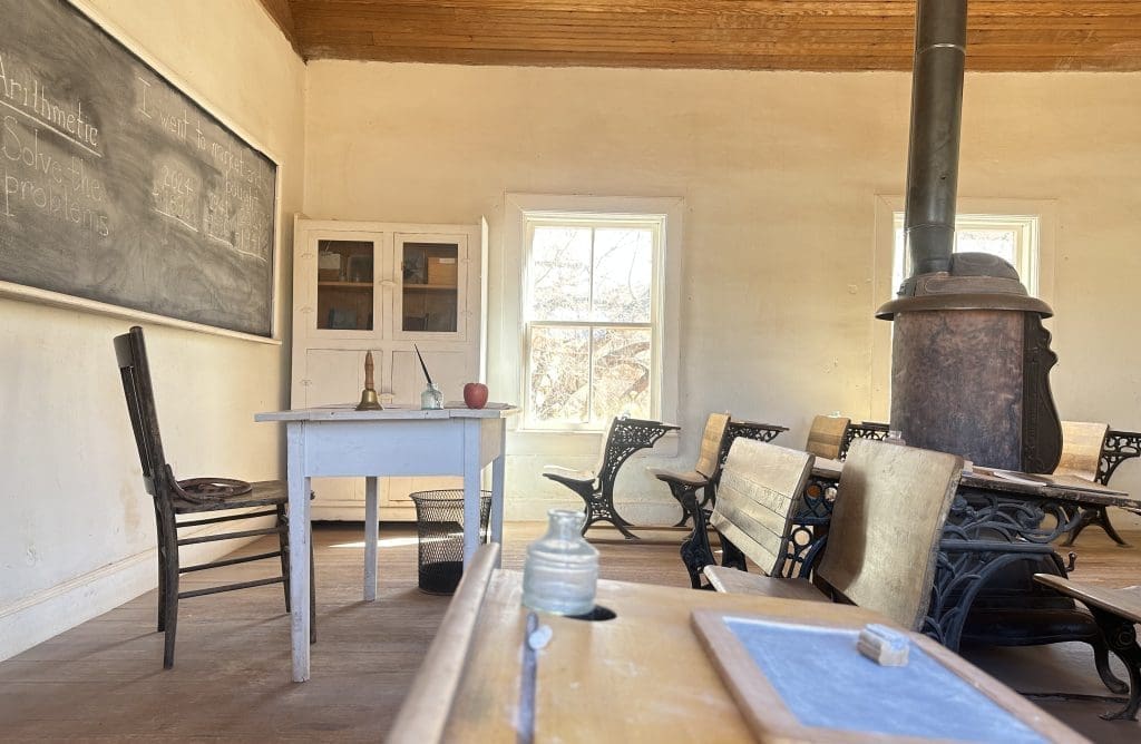 Peer through the window to see classroom of one-room historic schoolhouse in Fruita District
