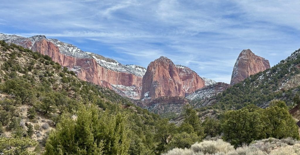 A towering rocky cliff under a clear blue sky.